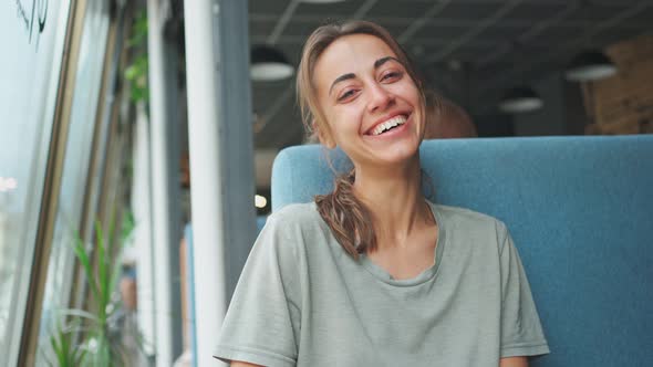 Happy Woman Sitting and Laughing About Funny Joke