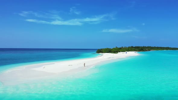 Wide angle aerial island view of a white sandy paradise beach and aqua blue water background in vibr