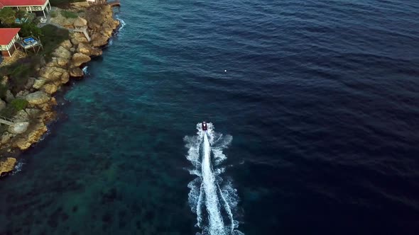 Aerial view dolly in tilt down of a jet ski on the shores of Jan Thiel Beach, Curacao, Dutch Caribbe