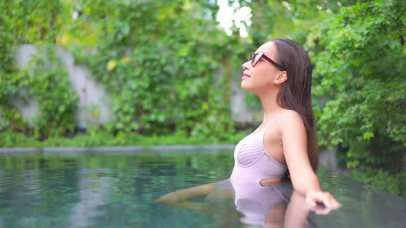 Young asian woman enjoy around outdoor swimming pool for leisure