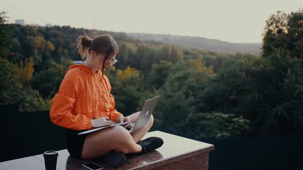 Frame of a Student Who Watches an Online Webinar and Takes Notes in the Middle of Nature