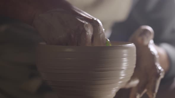 A Potter Sculpts Soft Clay with Wet Hands Creating Handmade Ceramic Creative Pot Rotating on Potter