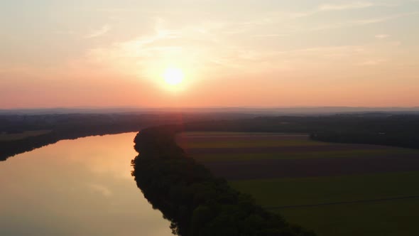 Gorgeous orange sun setting over the potomac river during dusk with tranquil river water drone aeria