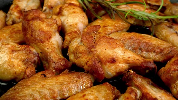 Many Fried Sliced Chicken Wings with Basil Twig with Crispy Crust Rotate Slowly