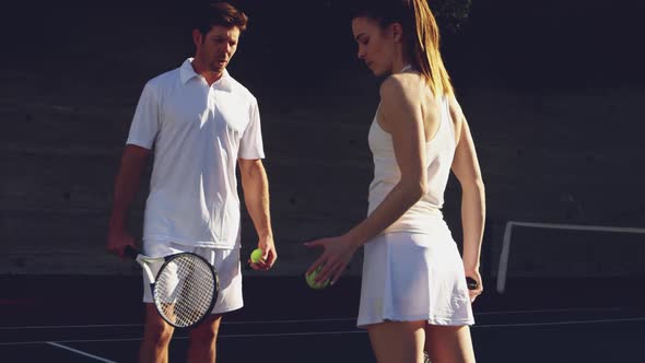 Woman and man playing tennis on a sunny day