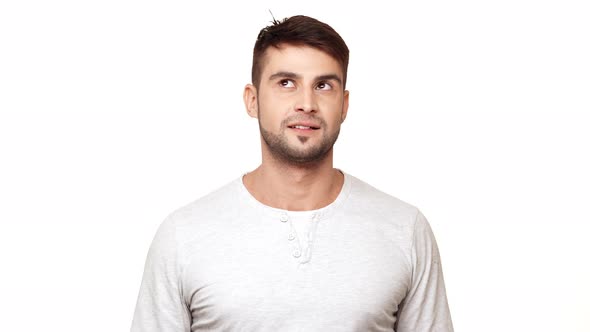 Concentrated Tough Guy in Sweatshirt Standing on White Background Trying to Notice Mosquito and