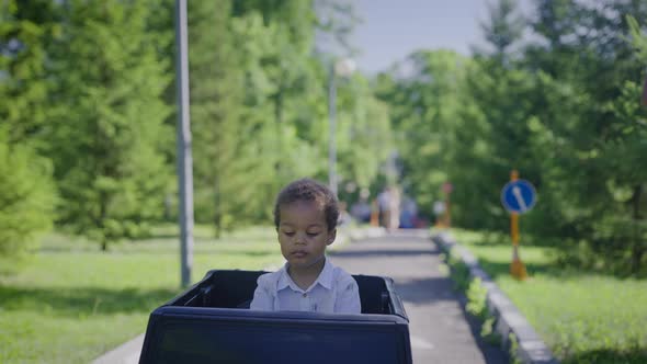 Cute African American Boy in a Toy Car