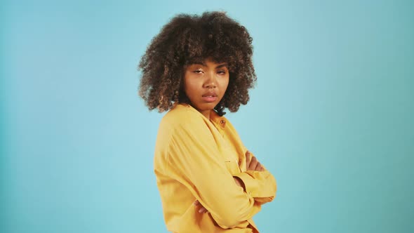 Africanamerican Woman Rolling Eyes Being Disappointed or Annoyed While Posing Sideways Against Blue