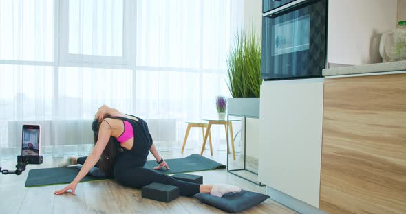 Athletic Young Woman is Doing a Split Stretching Recording It on the Phone