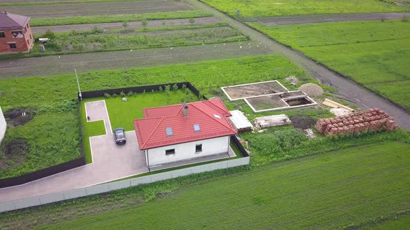 Aerial view of a private house and a yard with fence around.