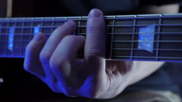 Close up of male hand playing on guitar strings, learning new chords