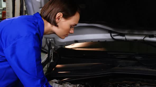 Female mechanic checking a car