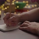Orbit Shot of Man Writes New Year Goals in Notepad with a Pencil Under Warm Light in the Evening - VideoHive Item for Sale