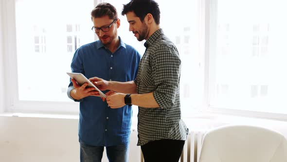 Business executives discussing over digital tablet