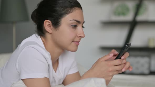 Indian Woman Using Smartphone in Bed