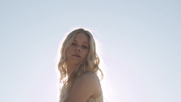 Blond Woman Dancing In Gold In Front Of Sun