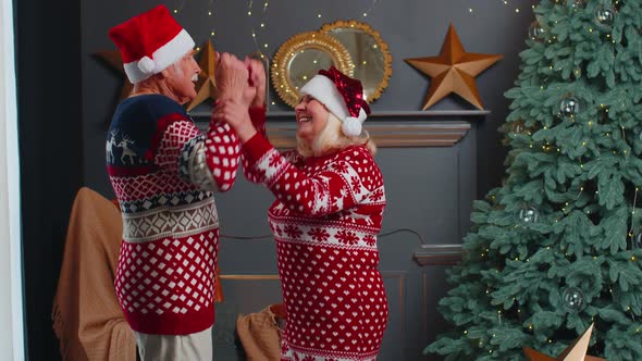 Joyful Senior Family Grandparents Couple Dancing at Home Near Christmas Tree Celebrating New Year