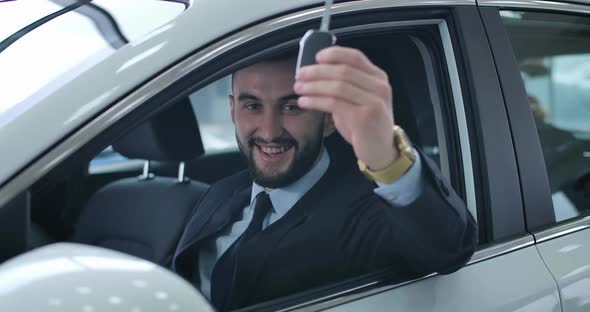 Successful Handsome Caucasian Businessman Showing Car Keys at Camera and Smiling