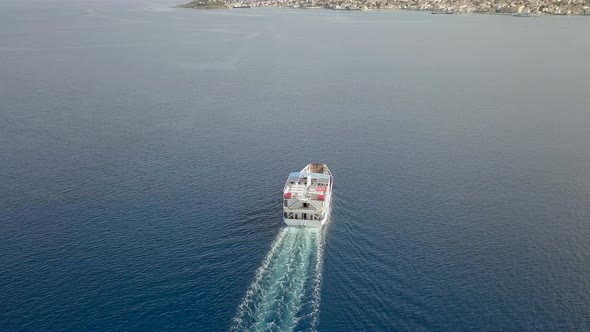 Aerial view following ferry boat with cars in the mediterranean sea, Greece.