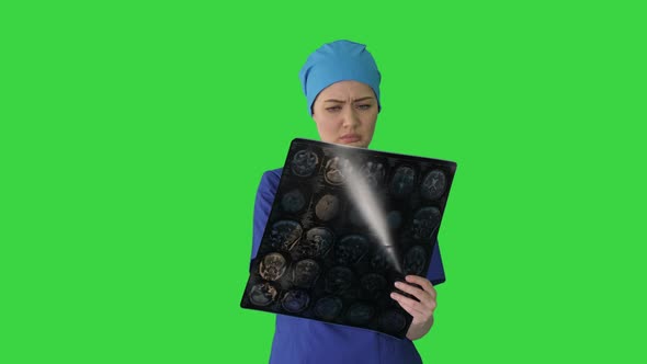 Female Doctor Looking at Brain Tomography on a Green Screen, Chroma Key.