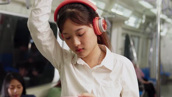 Young Woman Using Mobile Phone on Public Train