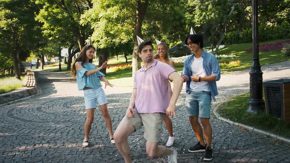 Young Friends Females and Males in Party Hats are Laughing and Fooling Around While Dancing in Green