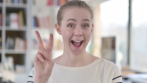 Portrait of Victory Sign By Successful Young Woman 