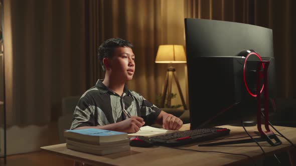 Asian Boy Learning Online, Raising Hand Distance Learning Online While Using Desktop Computer