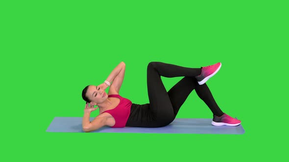 Beautiful Attractive Girl Doing Abs Exercises on a Mat on a Green Screen Chroma Key