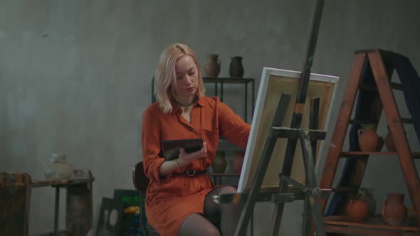 Female Painter Redrawing Picture From Tablet Pc to Easel