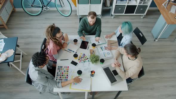 High Angle View of Young People Colleagues Talking and Drinking Coffee in Office