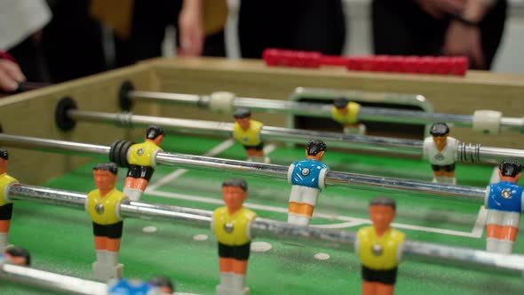 Unrecognizable people emotional play table football soccer closeup 4K. IT workers team resting