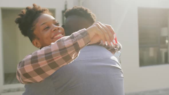 Video of happy african american couple embracing and showing keys to new house