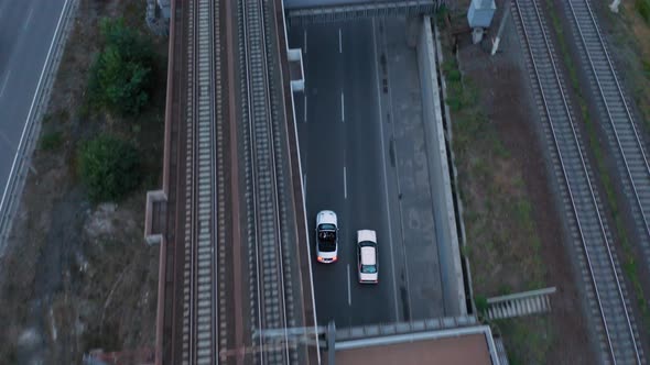 Aerial drone shot of a car driving on a bridge.