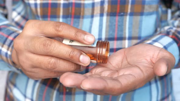Man's Hand with Medicine Spilled Out of the Pill Container