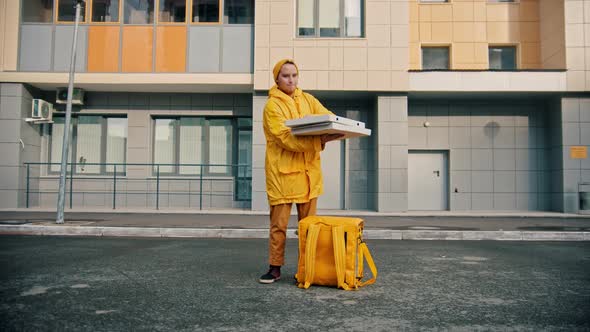 Man Courier in Yellow Clothes Delivers Food - Opens Up the Pizza Box and Smile