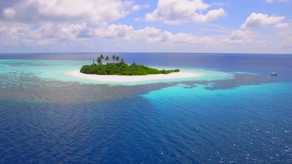 Aerial drone view of a coral reef and scenic tropical island in the Maldives.