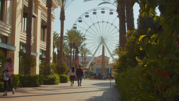 An outdoor shopping center in Southern California, featuring a giant ferris wheel attraction, with o