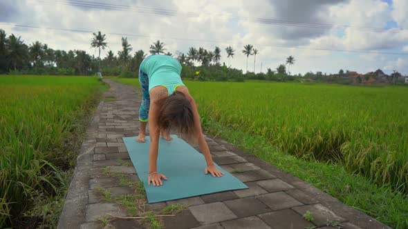 Slowmotion Shot of a Young Woman Practicing Yoga on a Beautiful Rice Field