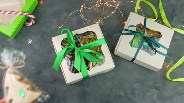 Gift boxes with dried fruits nuts individually wrapped set in female hands Christmas celebration