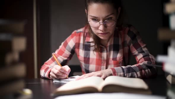 table, at which a student sits at night preparing for exams