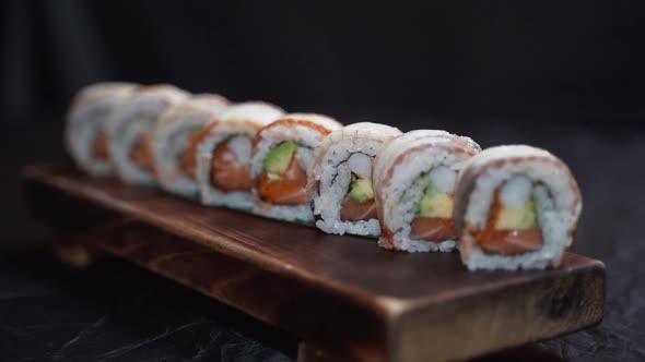 Tasty sushi rolls on wooden board. Food delivery