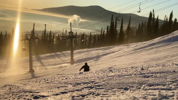 Silhouettes of People Skiing Along Snowy Mountain Slope