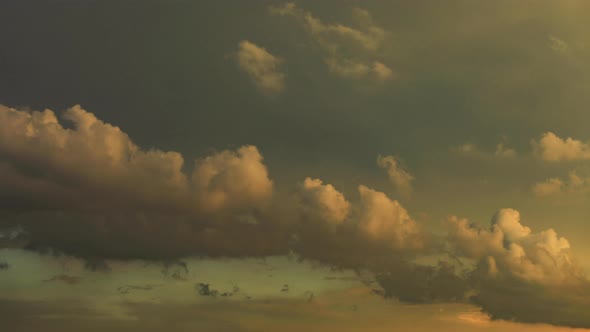 4k time lapse of warm golden cloud formation rolling through frame at sunset