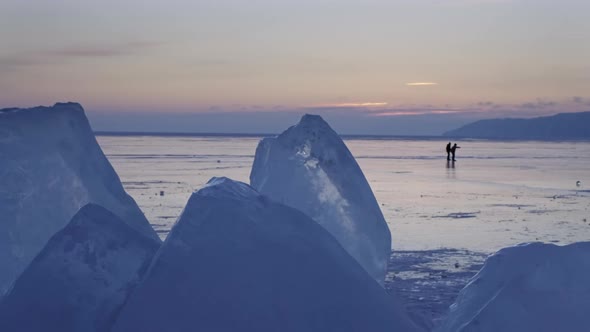 Pair at Sunset on Frozen Lake Baikal