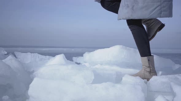 Legs of Unrecognizable Woman in Warm Jacket and Boots Climbing the Glacier, Walking on the Edge