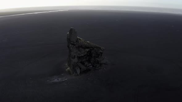 Drone Downward Tilting Shot of Sea Stack in Iceland and Sandy Horizon