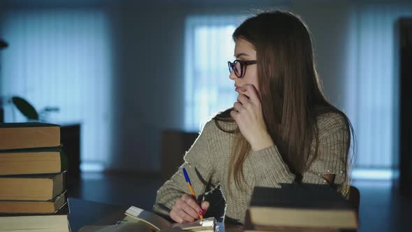 Beautiful Girl Studying in Library Leaning on Pen When Taking Notes From Books