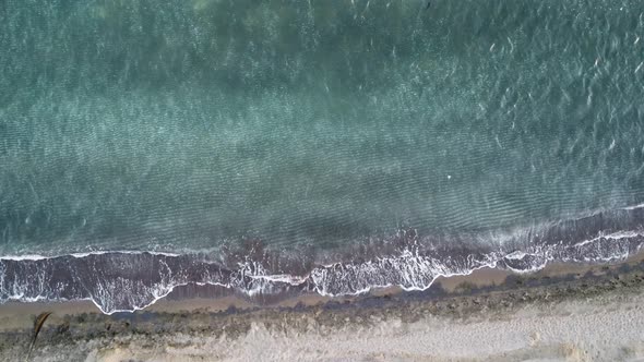 Cinematic aerial drone footage of waves crashing on the shore