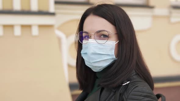 A girl during the Covid-19 pandemic in a medical mask walks around the city.